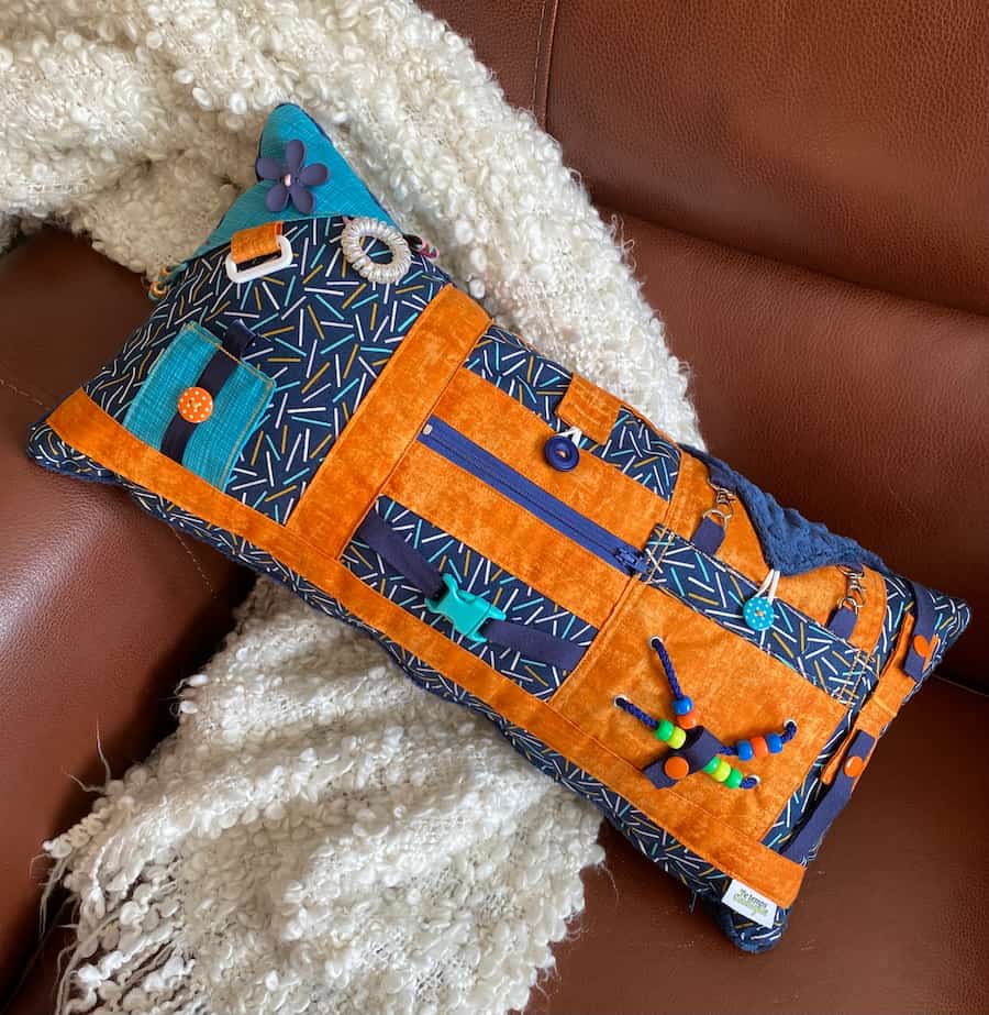 coussin orange et bleu sur divan, orange and blue cushion on couch