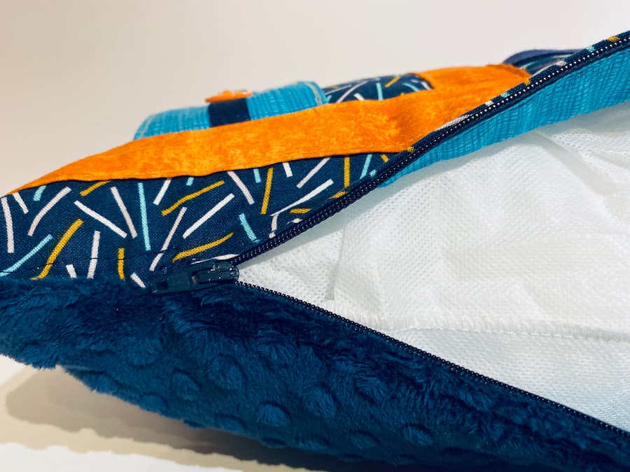 coussin orange et bleu vue rapprochée zipper, orange and blue cushion close-up view zipper