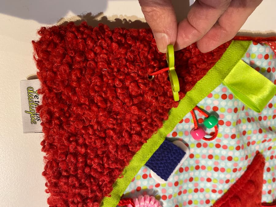 coussin vert et rouge vue rapprochée bouton fleur, green and red cushion close-up view flower button
