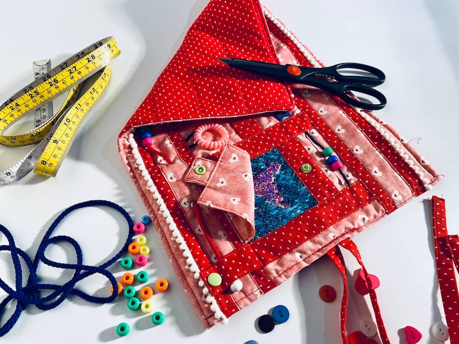 napperon rouge avec ruban jaune, ciseau et lacet bleu, red placemat with yellow ribbon, scissors and blue lace