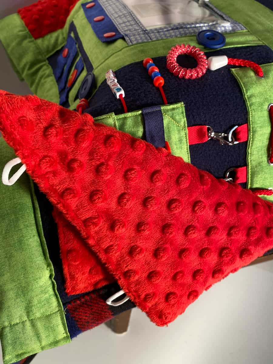 couverture bleu, verte et rouge vue rapprochée panneau d'activités, blue, green and red blanket close-up view activity panel